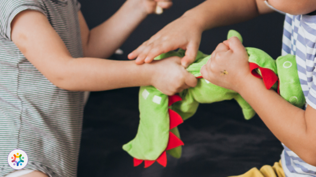 Imagem das mãos de duas crianças disputando um brinquedo