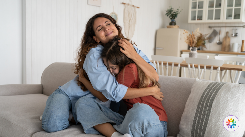 Criança abraçada à sua mãe, fonte de Apego Seguro.